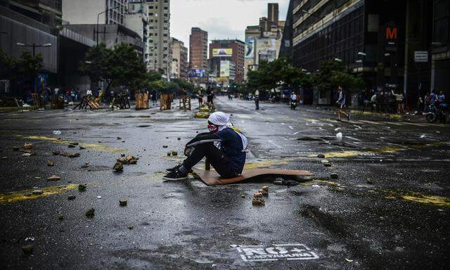 Die Antiregierungsproteste dauern an und könnten sich bis zum Wochenende weiter zuspitzen: Ein Jugendlicher beteiligt sich an einer Straßenblockade in Caracas. 