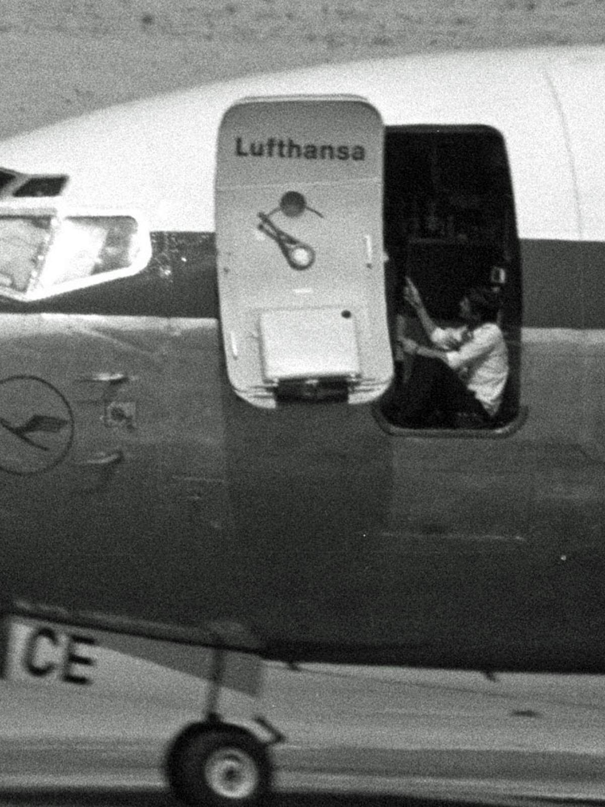 In Aden, Jemen, dem ursprünglichen Ziel der Terroristen, muss der Lufthansa-Flieger auf einer Sandpiste notlanden, die Regierung ließ die Landebahnen blockieren. Pilot Schumann wird jetzt zum Helden: Er inspiziert mit Erlaubnis seiner Entführer das Fahrwerk und macht dabei einen Abstecher zu Luftwaffen-General Ahmed Mansur. Schumann drängt Mansur vergeblich, auf die Forderungen der Terroristen einzugehen - und verabschiedet sich dann von dem General mit den Worten: "Ich bin sicher, sie werden mich umbringen." Zurück im Flieger jagen ihm die Entführer eine Kugel in den Kopf.Bild: Pilot Schumann im Flieger.