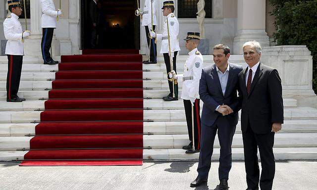 Greek PM Tsipras shakes hands with Austrian Chancellor Faymann in Athens
