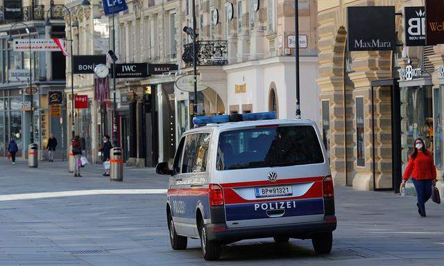 A police car drives next to closed shops in Vienna