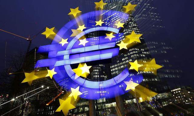 An illuminated euro sign is seen in front of the headquarters of the European Central Bank in the late evening in Frankfurt