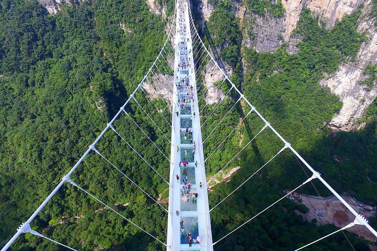 Superlativ für Schwindelfreie: In China können Besucher seit Samstag die weltweit längste und höchste Brücke aus Glas überqueren. Die 430 Meter lange und sechs Meter breite Konstruktion erstreckt sich 300 Meter über einen Canyon im Nationalpark Zhangjiajie.
