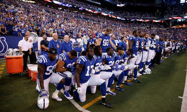 FILE PHOTO: Indianapolis Colts players kneel during the playing of the National Anthem before the game against the Cleveland Browns at Lucas Oil Stadium in Indianapolis