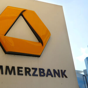 FILE PHOTO: FILE PHOTO: A sign for an ATM of Commerzbank is seen next to the headquarters of Deutsche Bank (R) in Frankfurt