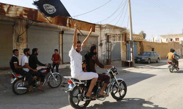 Resident of Tabqa city touring the streets on a motorcycle waves Islamist flag in celebration after Islamic State militants took over Tabqa air base, in nearby Raqqa city