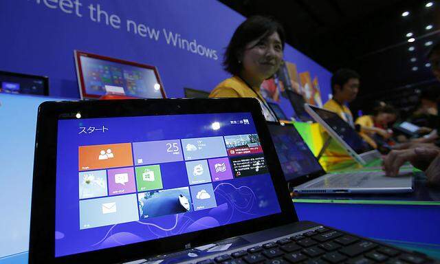 People try out Microsoft Corp´s Windows 8 operating system at an event for its debut at the Akihabara electronics store district in Tokyo