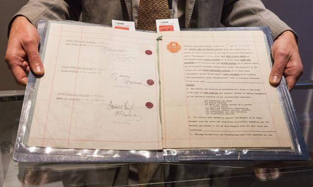 London UK 24 09 2015 A Sotheby s employee holds The Beatles signed managerial contract with Brian