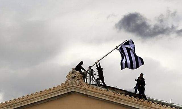 Parliament employees raise flag atop the parliament in Athens