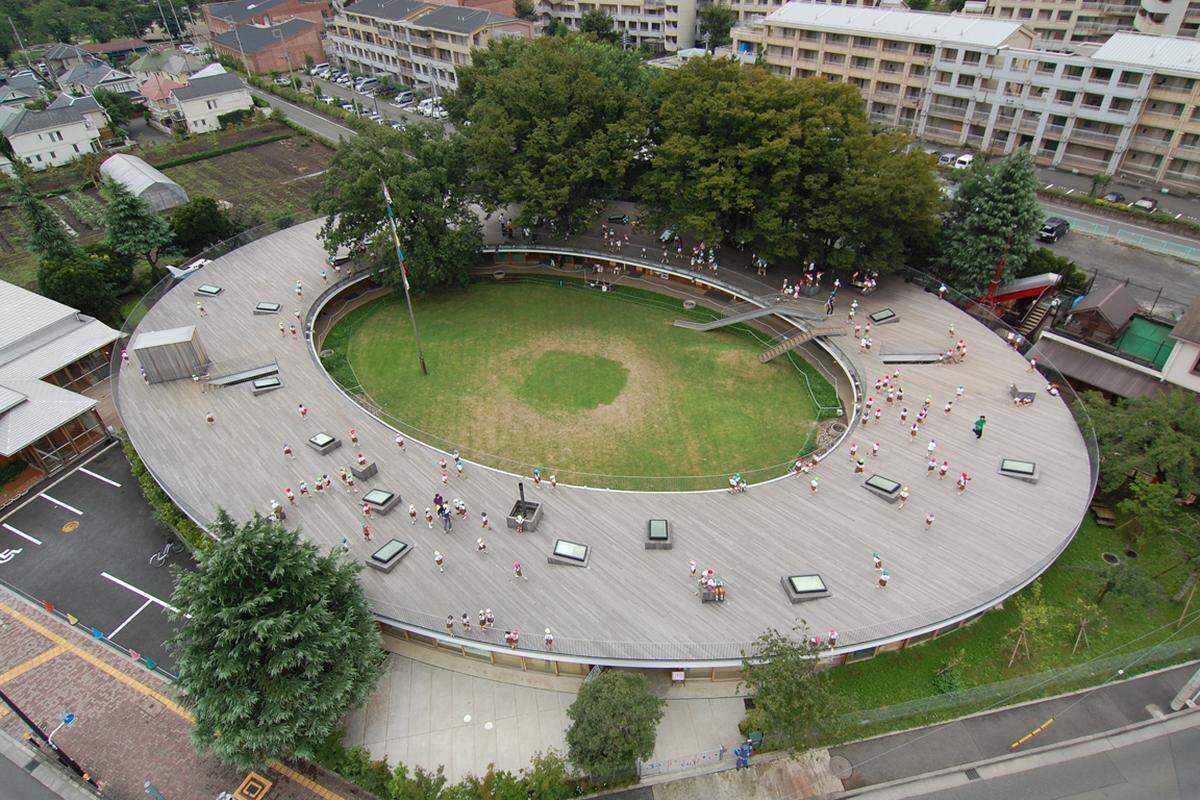 Von oben fällt die ungewöhnliche Architektur des Fuji Kindergartens, den Takaharu und Yui Tezuka vor zehn Jahren in Tokio entworfen haben, sofort auf. Warum er ringförmig ist? Weil er an den eigenen Kindern beobachtet habe, dass sie es lieben, im Kreis zu laufen.