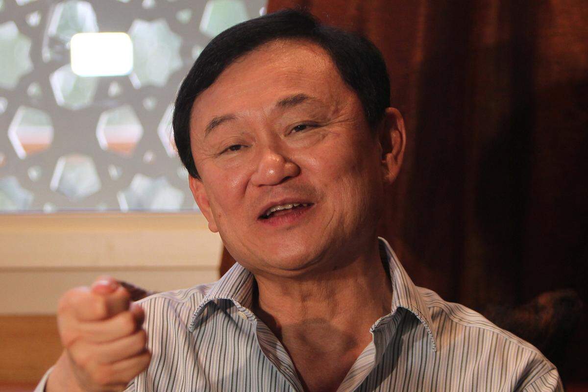 Der Ex-Regierungschef ist der Fadenzieher hinter der Regierungspartei Pheu Thai. "Thaksin denkt, Pheu Thai macht" war ihr Wahlslogan 2011. Er floh vor einer Verurteilung zu zwei Jahren Haft im Jahr 2008 ins Exil. Er und die Partei bestehen auf Wahlen - die Pheu Thai nach allen Umfragen wieder gewinnen würde.