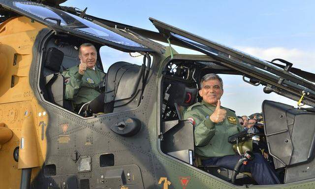 Turkey's President Gul and PM Erdogan pose in the cockpit of an assault helicopter in Ankara