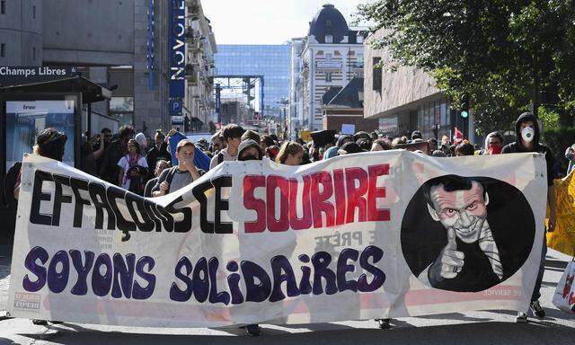 Proteste in Rennes: „Lasst uns dieses Lächeln auslöschen, seien wir geeint“, prangt neben der Macron-Karikatur auf dem Plakat. 