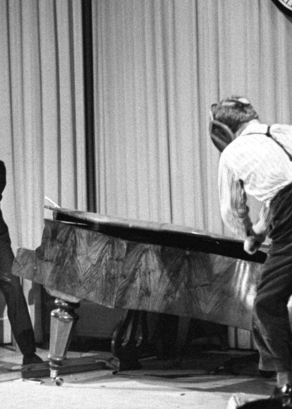 Friedrich Achleitner und Gerhard Rühm zertrümmern ein Klavier auf der Bühne. Wien 1959. 