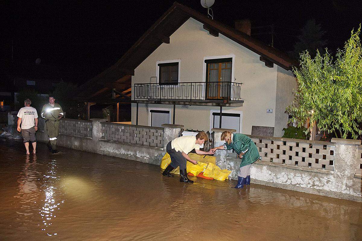 16 Feuerwehren standen mit 200 Mann im niederösterreichischen Bezirk Neunkirchen im Einsatz, um überflutete Keller auszupumpen und Muren zu beseitigen, berichtete Feuerwehrsprecher Franz Resperger. Im Bild: Einwohner in Altheim legen Sandsäcke vor ihre Häuser.