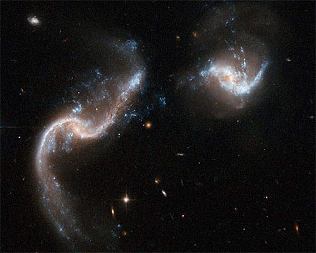 "Arp 256" besteht aus zwei Spiral-Galaxien kurz vor ihrer Kollision. Die Gravitationskräfte zwischen den beiden Galaxien hat Lichtbänder erzeugt, die 100 Millionen mal stärker leuchten, als die Sonne.