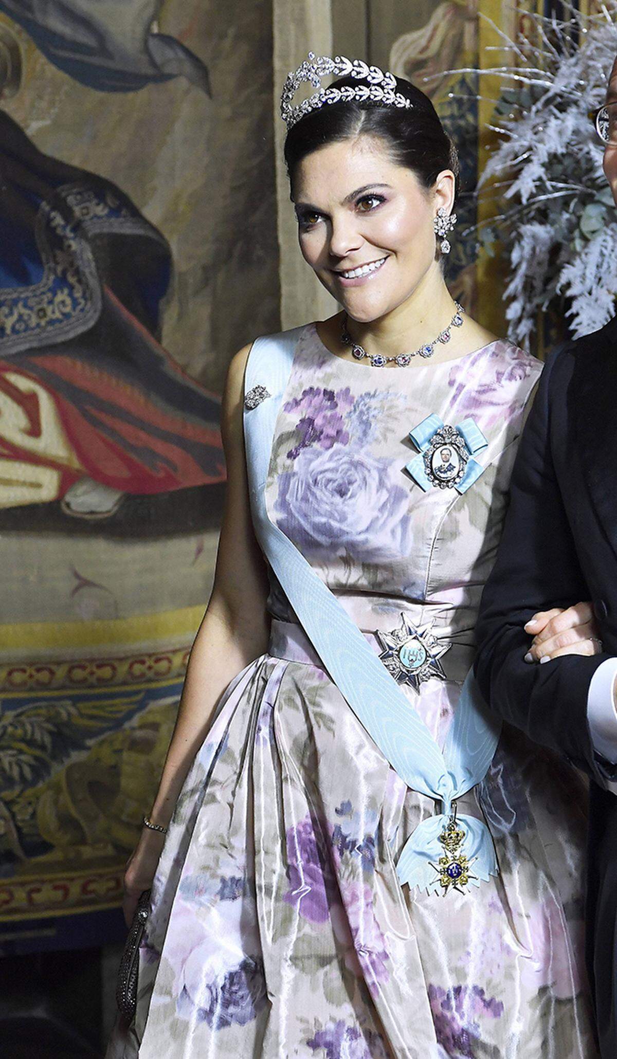 Dazu trug sie die "Lorbeerkranz-Tiara", die der 2013 verstorbenen Prinzessin Lilian gehört hatte - ihrer Großtante, die von ihren Großnichten Victoria und Madeleine heiß verehrt wurde. (Bei näherer Inspektion wirkt das Kleid der Kronprinzessin übrigens ein bisschen wie ein Duschvorhang aus den 1980er-Jahren.)