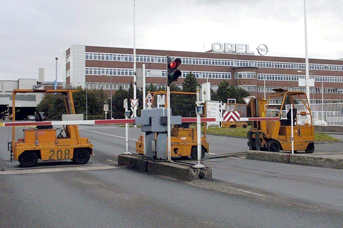 Die anhaltend schlechte Konjunkturlage zwingt zu weiteren Einsparungen. 2006 etwa sind in dem Opel-Werk in Bochum nur noch 27.661 Mitarbeiter beschäftigt, zehn Jahre davor waren es noch 44.700. Es kommt zu Streiks.   Gabelstapler blockieren den Eingang zum Werk in Bochum.