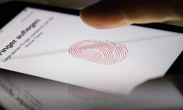 Symbolfoto zum Thema Touch ID. Ein Finger wird auf das Display eines Apple iPhone gehalten, auf dem das Symbol eines Fin