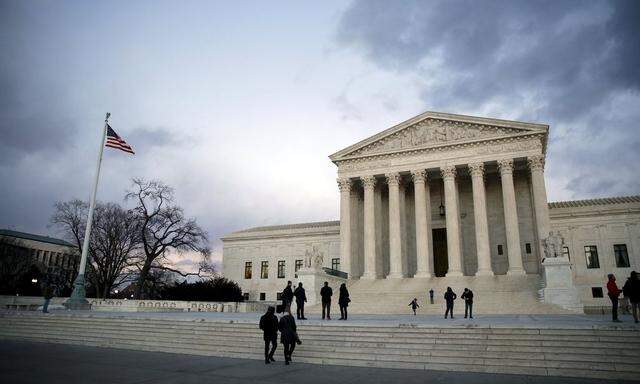People stand outside the Supreme Court building at Capitol Hill in Washington D.C.