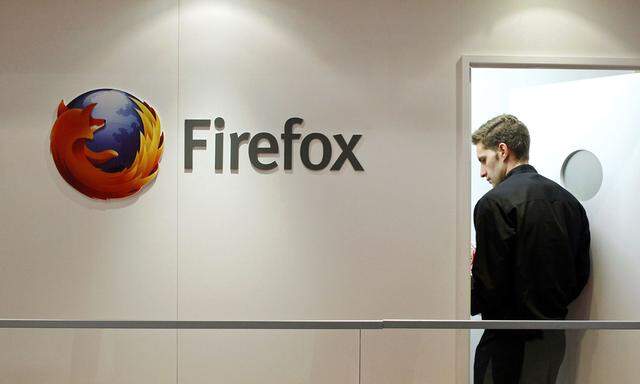 File picture of a man next to a Firefox logo at a Mozilla stand during the Mobile World Congress in Barcelona