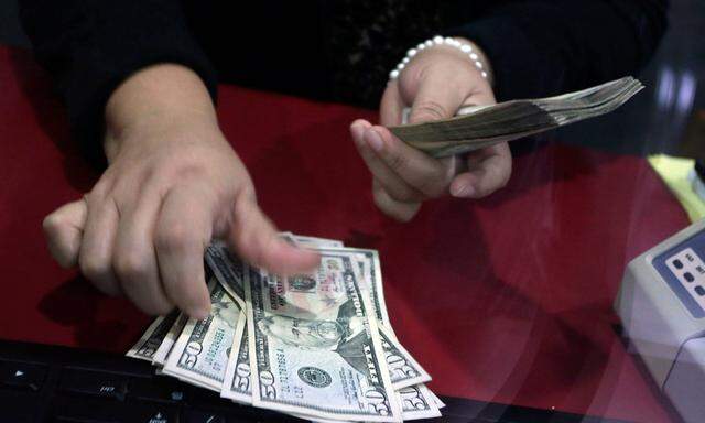 Employee counts U.S. dollar banknotes at a foreign exchange house in Monterrey