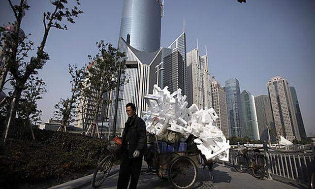 In this photo taken Dec. 7, 2010, a garbage collector stands with a backdrop of high-rise buildings i