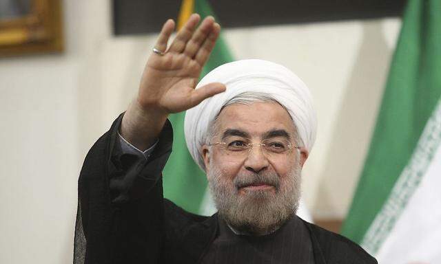 Iranian President-elect Hassan Rohani gestures to the media during a news conference in Tehran