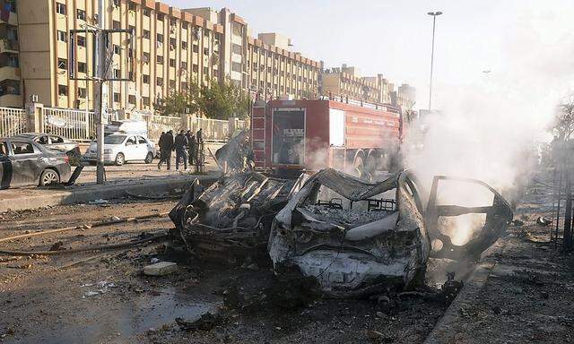 Damaged cars are seen at the site where two explosions rocked the University of Aleppo in Syria's second largest city