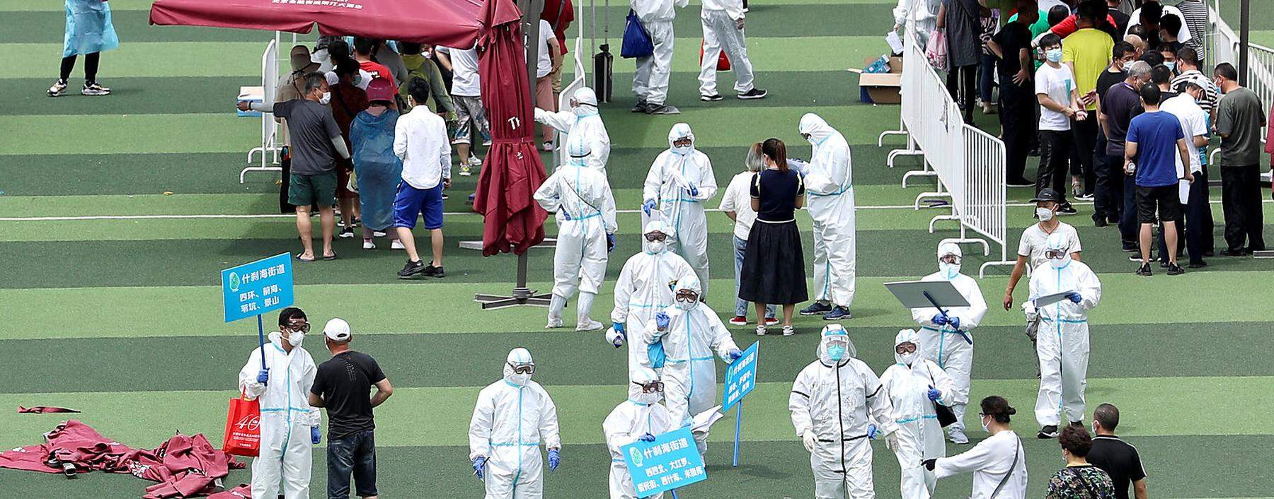 In einer Sportanlage in Peking kommen Tausende Menschen zum Coronavirustest.