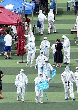 In einer Sportanlage in Peking kommen Tausende Menschen zum Coronavirustest.