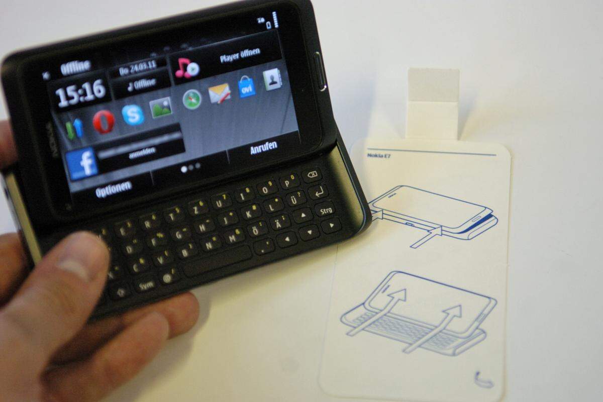 Zu Beginn sucht man aber eine Weile den Öffnungs-Mechanismus. Dieser ist beim E7 so gut versteckt, dass Nokia sogar eine Piktogramm-Anleitung dem Gerät beilegt, wie man die Tastatur freilegt.