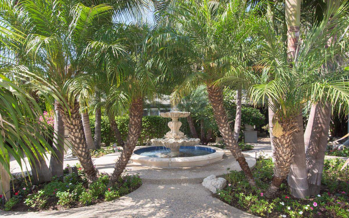 Der mit Palmen beschattete Brunnen befindet sich im Innenhof der Villa.