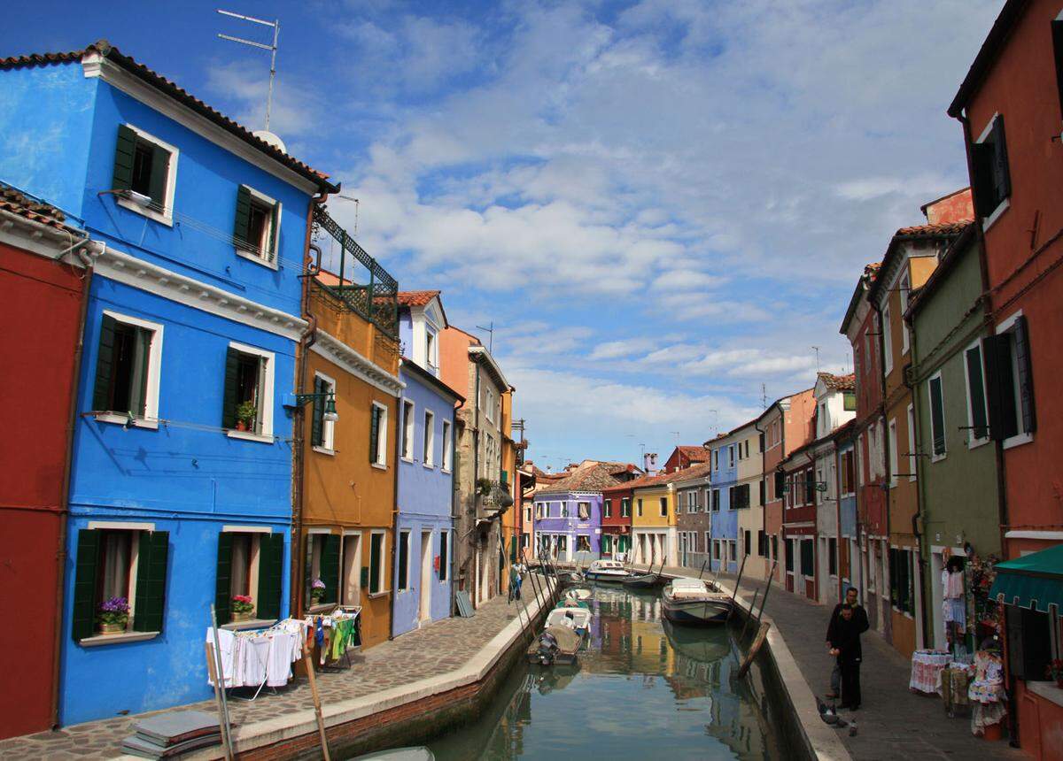 Die in der Lagune von Venedig gelegene Insel Burano erkennt man schon, wenn die Fähre noch weit von der Anlegestelle entfernt ist. Der Grund sind die vielen farblichen Kontraste. Nach der Überlieferung konnten Fischer ihre Häuser auch bei Nebel gut finden. Bis heute wird die Fassadenfarbe von der Regierung zugeteilt. 
