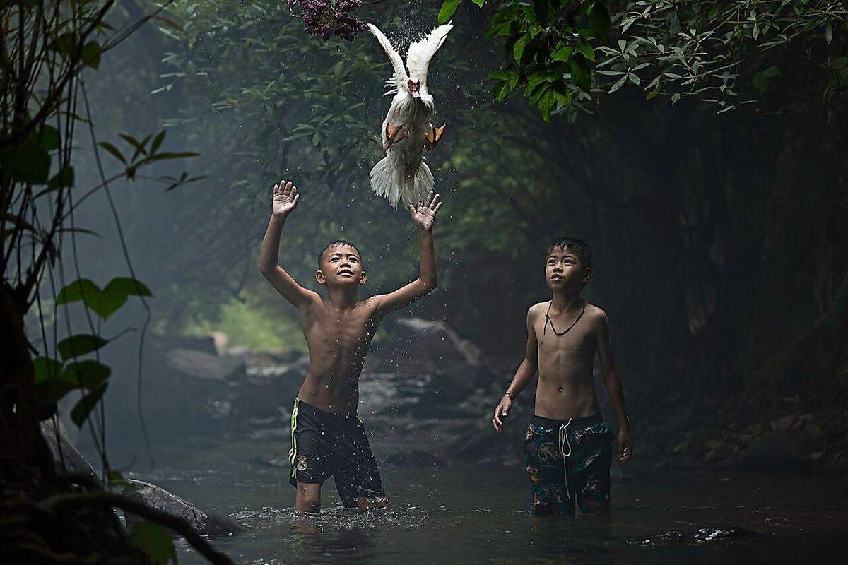 Ob die Jagd erfolgreich war? Zwei Jungen versuchen in der thailändischen Provinz Nong Khai eine Ente zu fangen.Credits: Sarah Wouters/ National Geographic Traveler Photo Contest 2015.