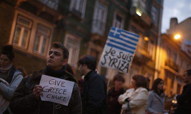 A man holds a placard during a vigil to support the newly elected Greek government