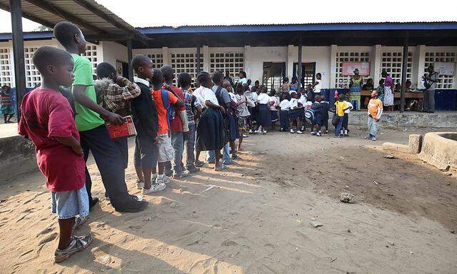 Schüler stehen in Liberia für einen Temperaturtest an, um Ebola weiter in Schach zu halten. Malaria-Prävention ist in Westafrika ins Hintertreffen geraten.