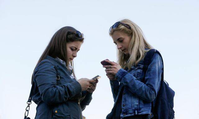 Women use their smartphones in Kiev