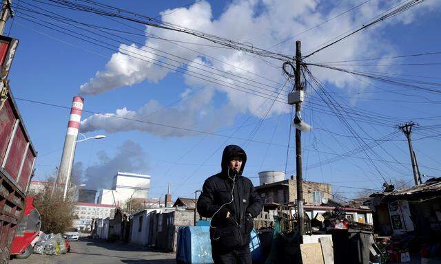 FILE PHOTO: A man walks near a coal-fired power plant in Harbin, Heilongjiang province, China