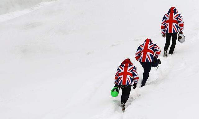 Three riders wear jackets with the design of the British Union Jack as the walk to the upper start position of the natural ice run of the Cresta Run at the private St. Moritz Tobogganing Club