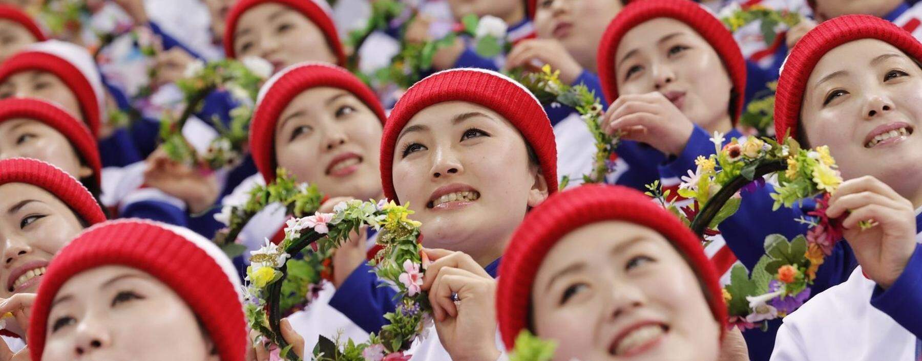 Members of North Korean cheering squad look at themselves in a mirror at a ladies' room at an expressway service area in Gapyeong