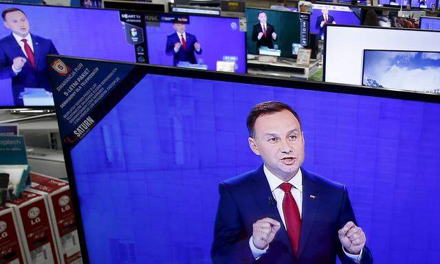 Andrzej Duda is seen on television screens at a shopping mall in Warsaw