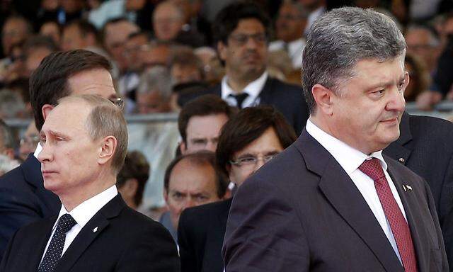Ukraine´s President-elect Petro Poroshenko walks past Russian President Vladimir Putin during the commemoration of the 70th anniversary of the D-Day in Ouistreham