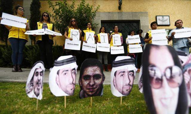Members of Amnesty International hold signs behind the photos of prisoners in Saudi Arabia during a demonstration for the release of Saudi blogger Raif Badawi from jail outside Embassy of Saudi Arabia in Mexico City