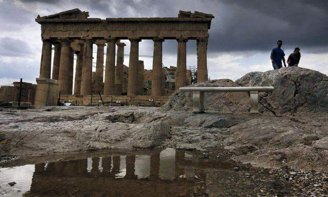 Tourists visit the Athens Acropolis during a rainy day