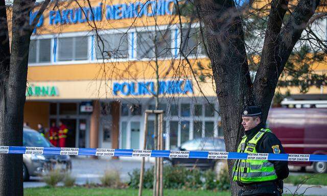 Policemen and paramedic are seen in front of the Ostrava Teaching Hospital, where six persons died after shooting on Tu