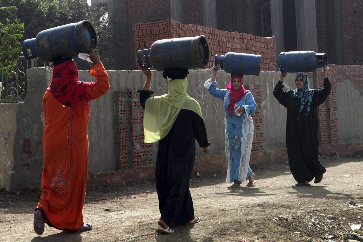 Frauen tragen Gasflaschen zur Wiederbefüllung in Kairo. Aufnahme vom 1. April 2013.