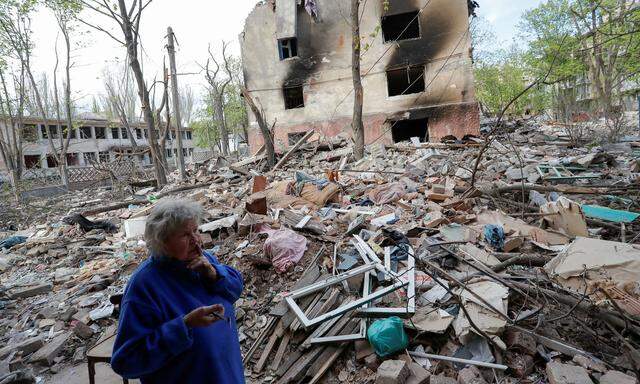 Eine Bewohnerin von Mariupol vor den Trümmern eines Wohnblocks. 