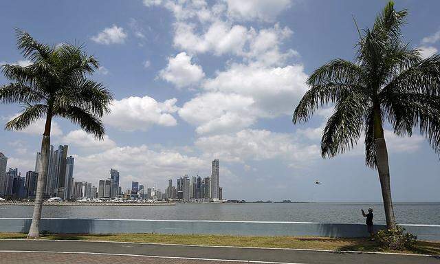 A man takes pictures on the seafront of Panama City