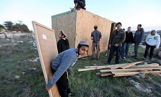 Siedler von Kiryat Arba and Kharsina bauen eine Holzhütte auf