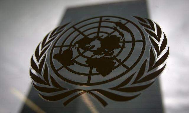 The United Nations headquarters building is pictured though a window with the UN logo in the foreground in the Manhattan borough of New York